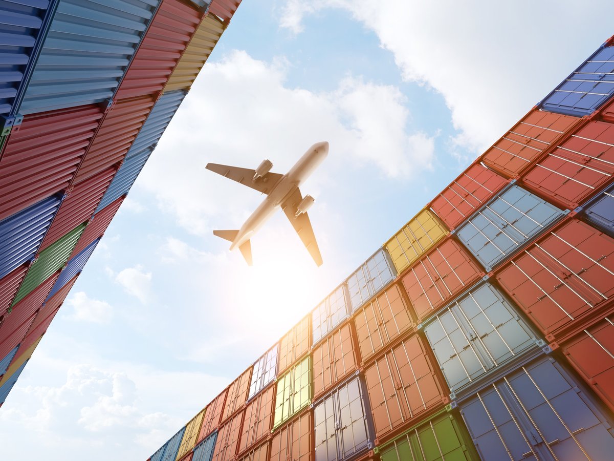 Cargo plane flying above container port